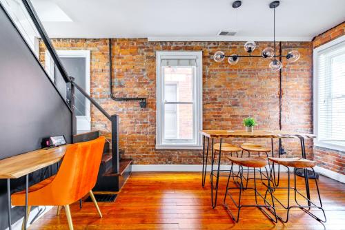 a room with a brick wall and a table and chairs at Jungle House Luxury Homes - Columbus Downtown Short North - Steps to Convention Center & Nationwide Arena - Sleeps up to 10 - Free Parking - Over 5,800 Five Stars in Columbus