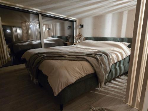 The Nut House - Cozy Escape in Tartu في Soinaste: غرفة نوم بها سرير كبير ومرآة