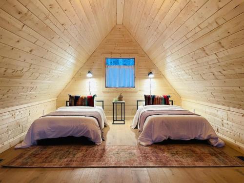 zwei Betten in einem Zimmer mit Dachboden in der Unterkunft Camp Carter Nordic House in Mathias