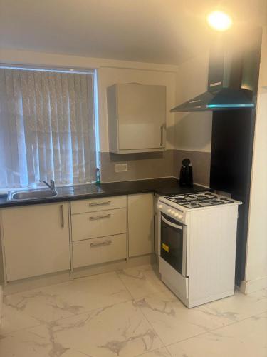 una cocina con una estufa blanca horno superior al lado de una ventana en Citywise Guest House, en Sands