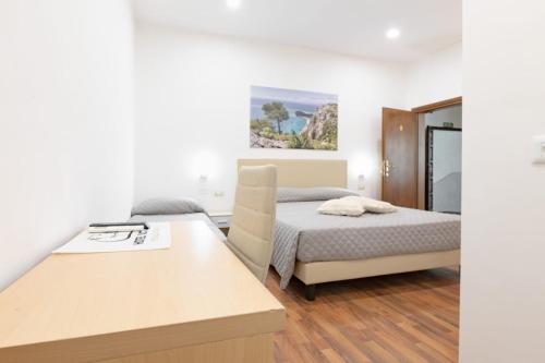 una camera da letto con un letto e una scrivania di Hotel Victoria a Finale Ligure