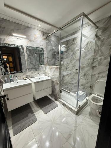 a bathroom with two sinks and a shower and a toilet at Apartment luxurious a Hay Riad in Rabat