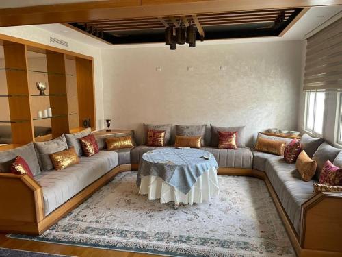a living room with a couch and a table at Apartment luxurious a Hay Riad in Rabat