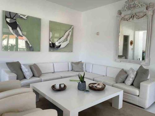 The White House 1 في آنذروس: غرفة معيشة مع أريكة بيضاء وطاولة