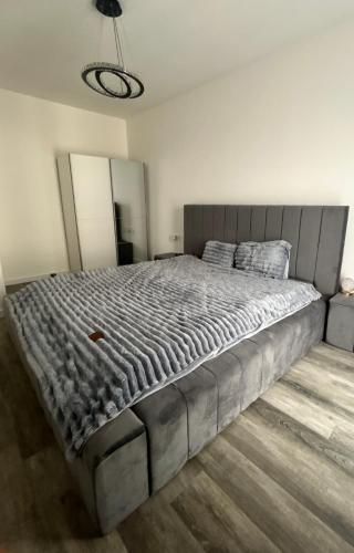 a large bed in a white bedroom with a large mattress at Luxury Apartment private parking in Craiova