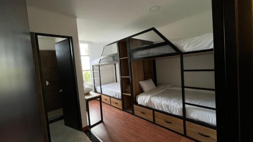 a room with two bunk beds and a mirror at Hotel Laverdieri in Suba