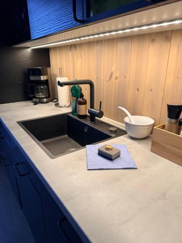 a kitchen with a sink and a counter top at KB - Nordic Luxury Rorbu in Stamsund
