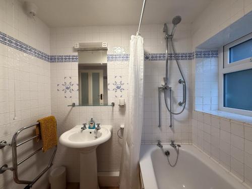a bathroom with a sink and a tub and a shower at Thin End in Seaview