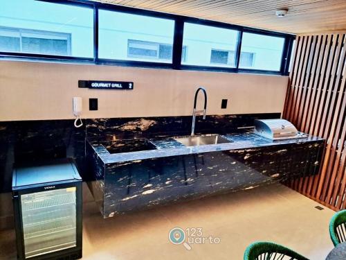 uma cozinha com um lavatório e um telefone no balcão em Hit Cabo Branco by 123Quarto em Tambaú