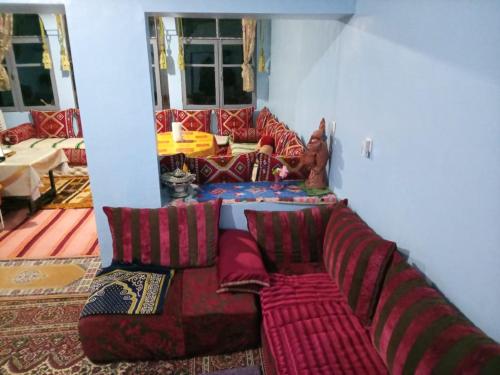 a living room with a couch with pillows at Palmas Magramane in Oulad el Guern