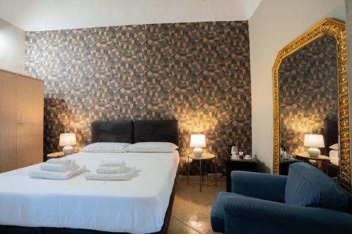 um quarto com uma cama com espelho e um sofá azul em Hotel Trieste em Catânia