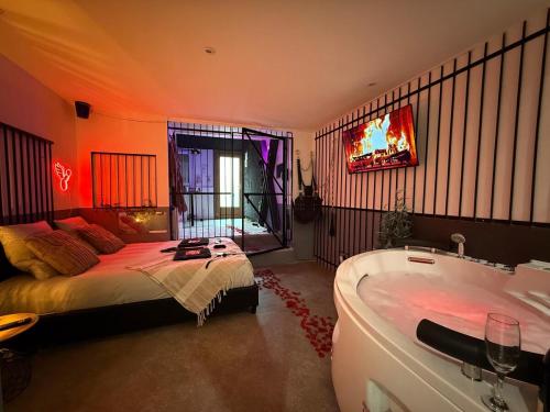 una camera da letto con un letto e una vasca da bagno di The Forbidden Suite - prison a Souppes-sur-Loing