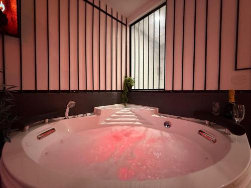 una grande vasca da bagno in una stanza con finestre di The Forbidden Suite - prison a Souppes-sur-Loing