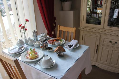 a table with plates of food on top of it at Tyndale B&B Torquay in Torquay