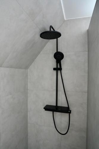 a shower with a black shower head in a room at Altstadt Apartment Chalet in Haltern