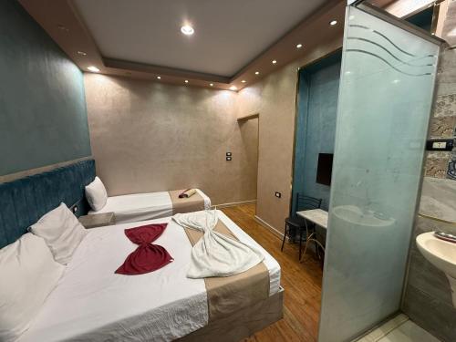 2 camas en una habitación con lavabo y ducha en The-Cairo Plazario Downtown Hotel, en El Cairo