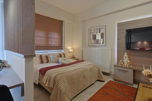 a bedroom with a bed and a flat screen tv at SIGMA - Signature Living & Easy Parking by Optimum Link in Katerini