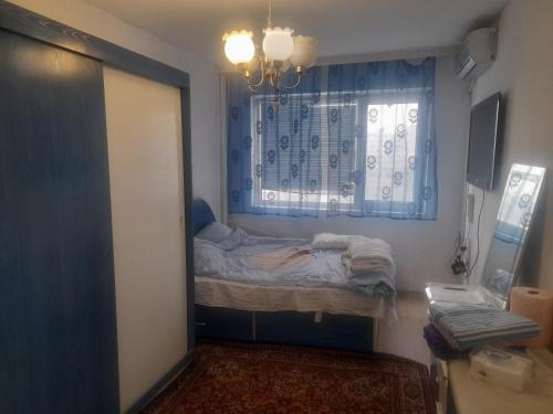Una pequeña habitación con una cama y una ventana. en prensess, en Varna