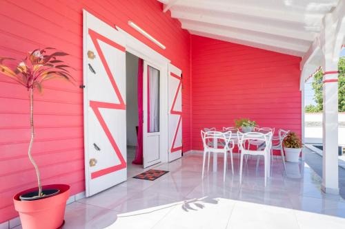 a red room with a table and a white door at Villa Guenaslo 2 in Saint-François