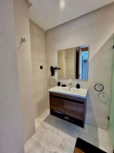 a bathroom with a sink and a mirror at Chic Cocoon & Impeccable Sea View in Zenata in Aïn Harrouda