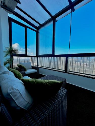 a living room with a couch and large windows at Chic Cocoon & Impeccable Sea View in Zenata in Aïn Harrouda