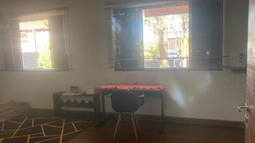 a desk and a chair in a room with windows at Med House in Guaíra