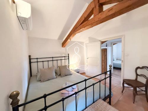 La Villa Andéria, petit cocon provençal في كاليان: غرفة نوم صغيرة بها سرير وكرسي