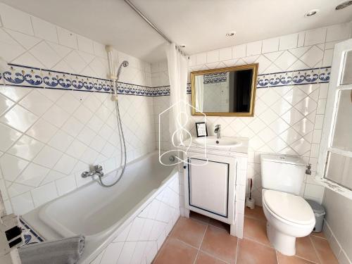 La Villa Andéria, petit cocon provençal في كاليان: حمام مع حوض استحمام ومرحاض ومغسلة