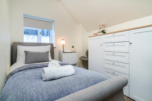 a bedroom with a bed and a dresser at Enigma Lodge in Stratford-upon-Avon