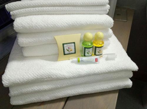 a pile of towels with bottles of toothpaste and a picture at PEOPLE Loft Tverskaya Hotel in Moscow