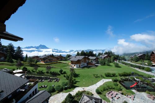 a small village with a green field and houses at Chalet RoyAlp Hôtel & Spa in Villars-sur-Ollon
