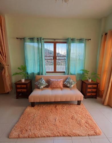 a living room with a couch in front of a window at Entire Home with King Bed in Chiang Mai