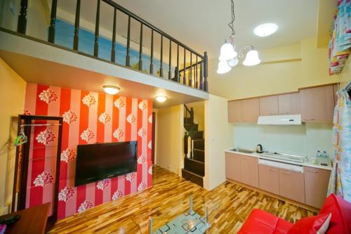 a living room with a staircase and a kitchen at Miaoli Sanyi Bo Wu Guan Homestay in Sanyi