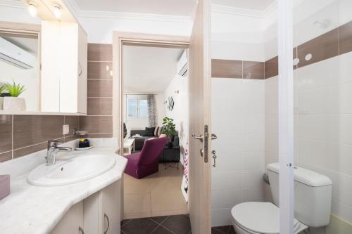 a bathroom with a sink and a toilet at Villa Alya View in Barbati