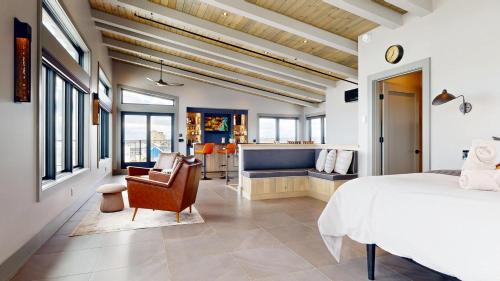 een slaapkamer met een bed en een stoel en een keuken bij Tidal House in Surfside