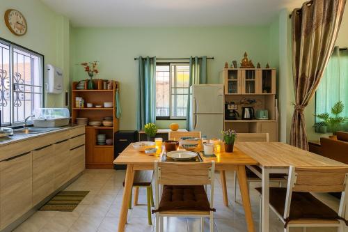 een keuken met een houten tafel en een eetkamer bij Entire Home with King Bed in Chiang Mai