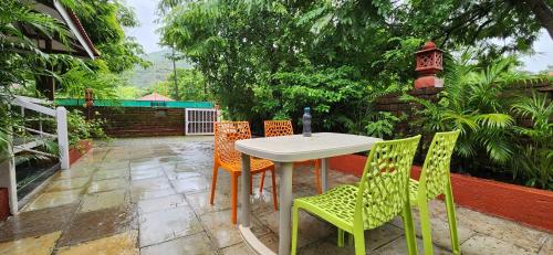 uma mesa e cadeiras sentadas num pátio em Gulmohar Villa tamhini ghat, Kolad Rafting 