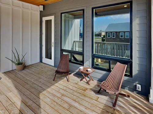 two chairs on a porch with a view of a balcony at Serenity At Port A in Port Aransas