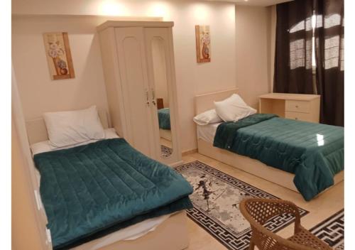 a bedroom with two beds and a mirror at رويال للغرف الفندقية in Mît Khamîs