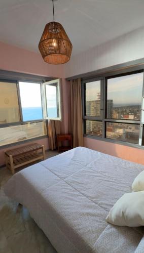 een slaapkamer met een groot bed en twee ramen bij Miramar Vista al Mar in Miramar