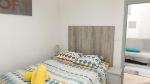 een slaapkamer met een bed met een gele knuffel erop bij T2 type new yorkais in Ajaccio
