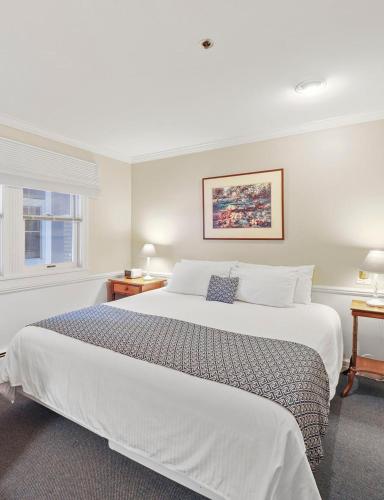 a bedroom with a large white bed and a window at 109 Water Street Inn in Boyne City