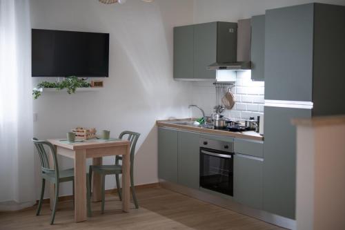 een keuken met een spoelbak en een tafel met stoelen bij Casa di Viola - Ortensia in Latina