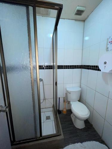a bathroom with a toilet and a glass shower at Habitaciones Pabla in Santiago