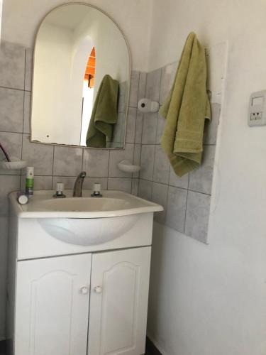 un bagno con un lavandino bianco e uno specchio di Bajada 1-2 a Las Grutas