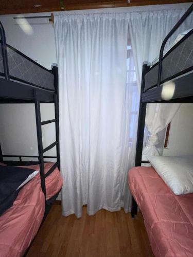 a bedroom with two bunk beds and a window at Habitaciones Pabla in Santiago