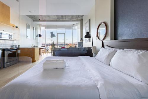 een slaapkamer met een groot wit bed en een keuken bij Les Immeubles Charlevoix - Le 760-108 in Québec