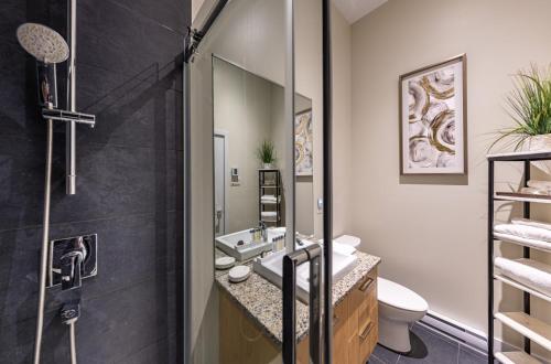 een badkamer met douche, wastafel en toilet bij Les Immeubles Charlevoix - Le 760-108 in Québec