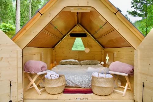 a bedroom in a tree house with a bed and two baskets at Campeggio Treinke Sauris in Sauris