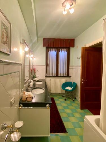 a bathroom with a sink and a mirror and a chair at Ai Quattro Ulivi B&B in Monte Urano